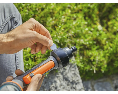 Osoba vkládá knoflíkovou baterii do zavlažovací pistole