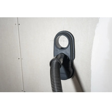 Zásuvka pro připojení vysavače s připojenou hadicí vysavače na stěně