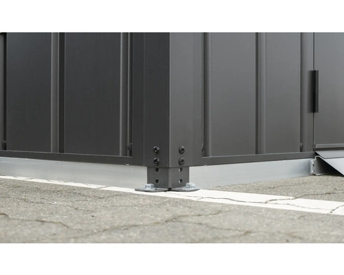 Detail rohu zahradního domku s šroubovým upevněním k zemi.