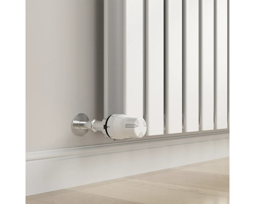 Detail bílého radiátoru s termostatem na zdi