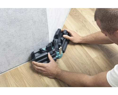 Osoba používá pokosnici k řezání podlahových lišt.