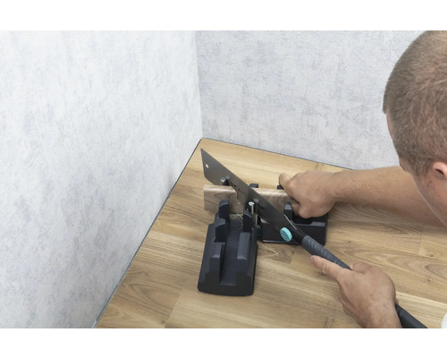 Ruční pila s pokosnicí při řezání kusu dřeva