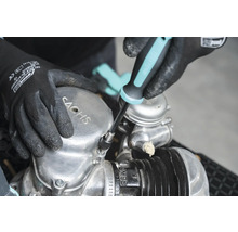 Osoba opravuje motor Sachs pomocí šroubováku.