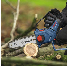 Akumulátorová řetězová pila řeže kmen stromu, logo Bosch