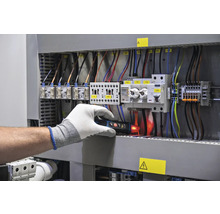 Elektrikář kontroluje rozvaděč pomocí zkoušečky napětí
