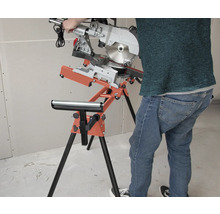 Pokosová pila na stojanu s válečkovou podpěrou v dílně.