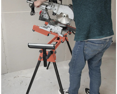 Pokosová pila na stojanu s válečkovou podpěrou v dílně.