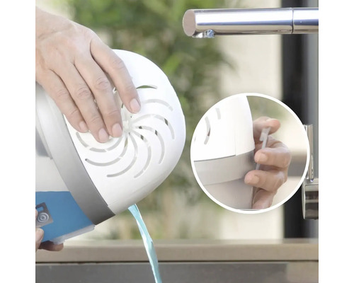 Osoba vylévá vodu z odvlhčovače vzduchu do umyvadla.