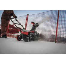 Osoba obsluhuje sněhovou frézu k odklízení sněhu.