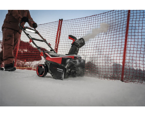 Osoba obsluhuje sněhovou frézu k odklízení sněhu.