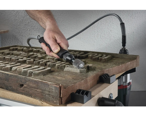 Muž používá ohebný hřídel na dřevěném obrobku