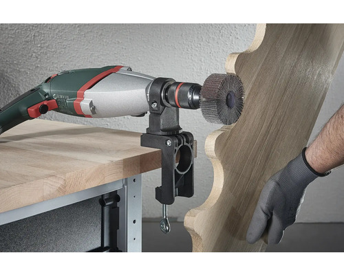 Elektrické nářadí s brusným kotoučem opracovává dřevo s držákem připevněným ke stolu