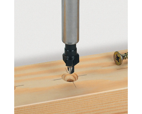 Forstnerův vrták vrtá otvor do dřevěné desky.