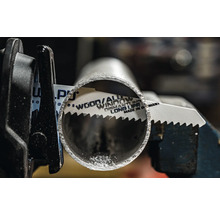 Pilový list na kov řeže kovovou trubku v držáku