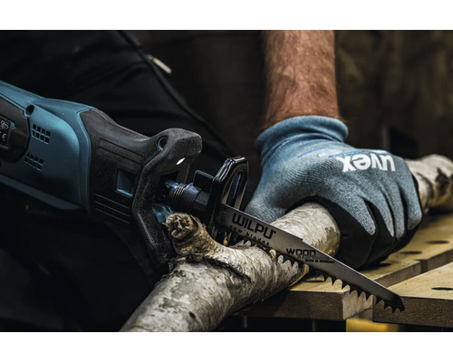 Osoba řeže větev elektrickou pilou ocaskou a pilovým listem Wilpu.