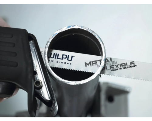 Pilový list na kov při řezání kovové trubky.