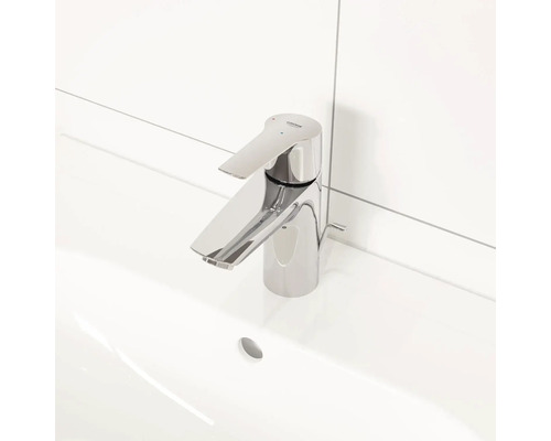 Umyvadlová baterie z kovu s logem Grohe na bílém umyvadle