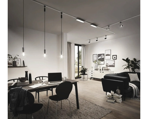 Obývací pokoj s jídelním stolem, pohovkou a kolejnicovým systémem se světlomety a závěsnými svítidly.