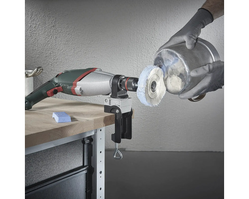 Vrtačka s lešticím nástavcem a svěrákem na pracovním stole leští kovový kbelík