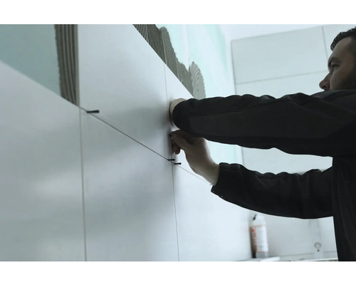 Obkladač pracuje s dlaždicemi a obkladačskými šňůrami