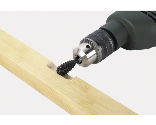 Vrtačka s rašplovým nástavcem obrábí kus dřeva.