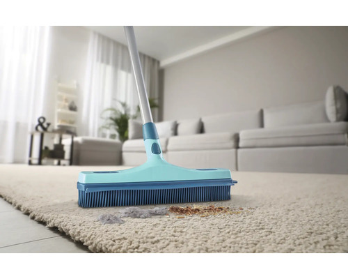 Kartáč s gumovými štětinami na koberci se špínou