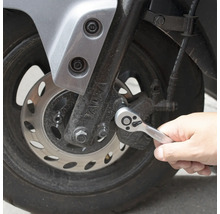 Osoba používá ráčnu na motocyklu.