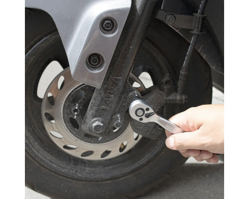 Osoba používá ráčnu na motocyklu.