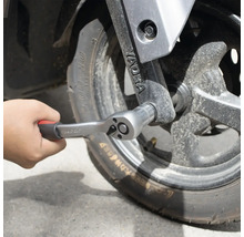 Ruka upevňuje ráčnu na kolo.