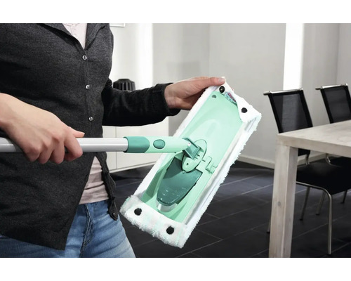 Žena drží v ruce mop na podlahu s návlekem z mikrovlákna