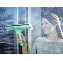 Žena čistí okna stěrkou na okna