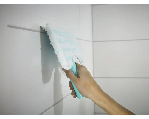 Ruka utírá dlaždice plochým mopem