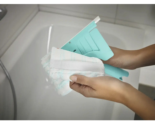 Stěrka s omyvatelným potahem v rukou před vanou