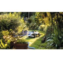 Robotická sekačka v provozu v zelené zahradě