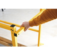 Žluté lešení s rukou, která ho drží