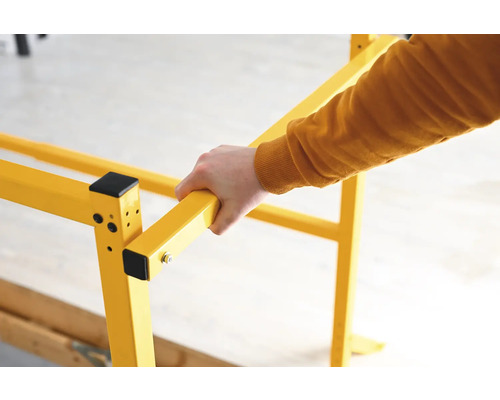 Žluté lešení s rukou, která ho drží