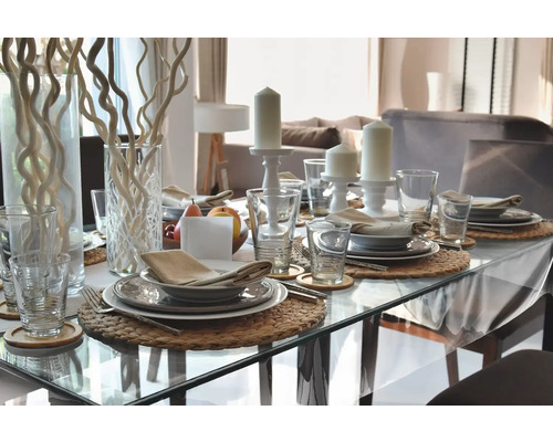 Slavnostně prostřený jídelní stůl s nádobím, sklenicemi, svíčkami a dekorací