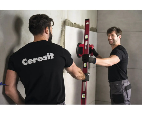 Obkladač s přísavkou na obklady a vodováhou při práci