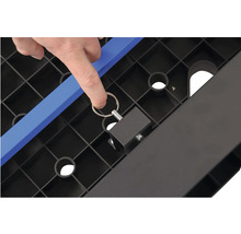 Detail montážního dílu na černém plastovém regálu