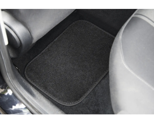 Černá podlahová rohož v prostoru pro nohy automobilu.