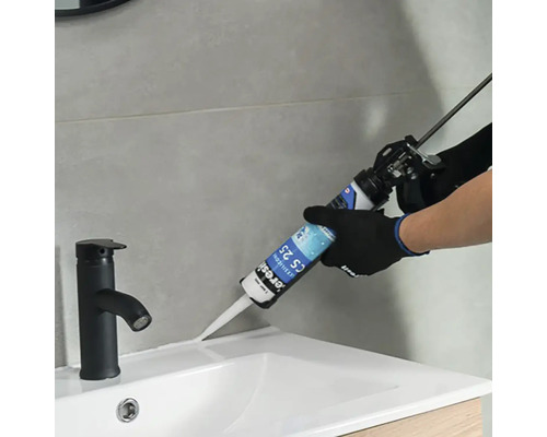 Aplikace těsnicího materiálu na okraj umyvadla pomocí kartuše.
