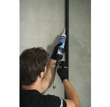 Řemeslník utěsňuje sprchovou stěnu silikonem. Viditelné logo Ceresit.