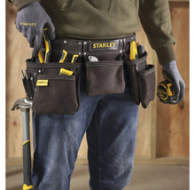 Řemeslník s pásem na nářadí značky Stanley, vybavený různým nářadím