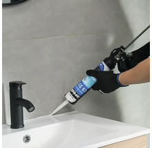 Nanášení tmelu pomocí aplikační pistole v koupelně