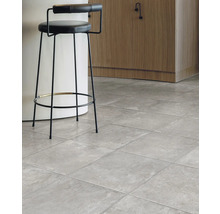 Interiér s šedou dlažbou a barovou stoličkou