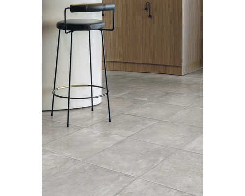 Interiér s šedou dlažbou a barovou stoličkou