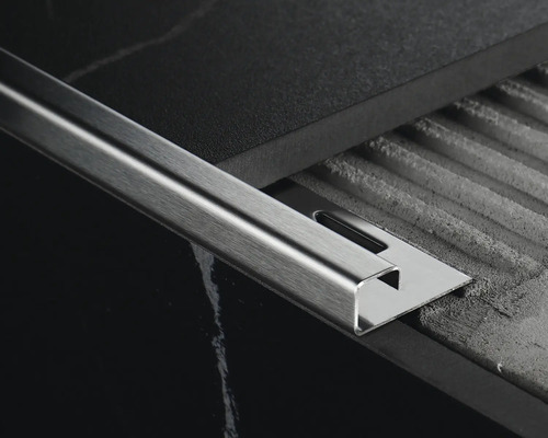 Kovová dlažební lišta na dlaždicovém povrchu