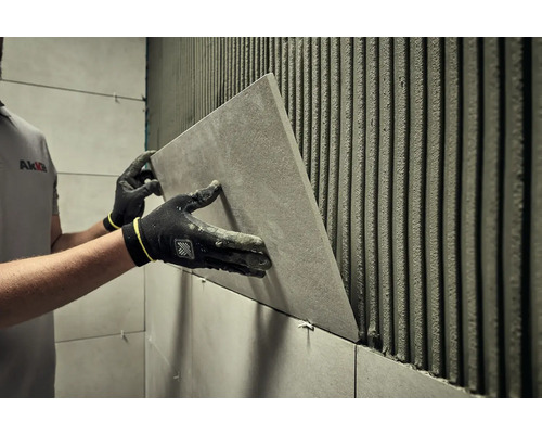 Dlaždič instaluje obklad v koupelně