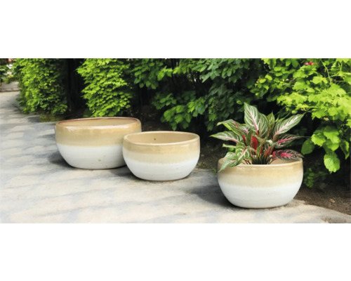 Tři keramické květináče na zahradě.