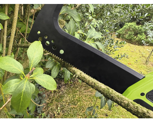 Akumulátorová prořezávací pila řeže větev.